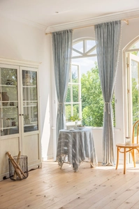 Close-up of light blue striped curtains and tablecloth with elegant cream fringe tassels