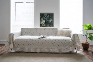 Detailed view of pastoral lemon floral pattern on cream sofa cover with ruffled lace edges