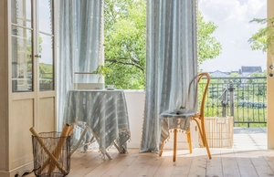 Detail of blue striped linen curtain with handmade tassels and rustic woven texture
