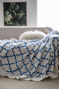 Close-up of diamond print sofa cover with ruffled edges on a modern gray couch