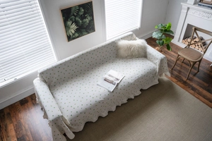 Detail of ruffle edge and lemon floral print on off-white sofa cover throw blanket