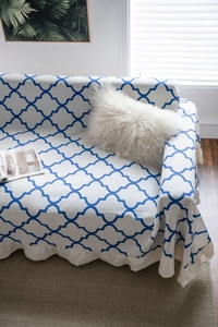 Detail of blue geometric rhombus pattern sofa cover with elegant ruffled edge design