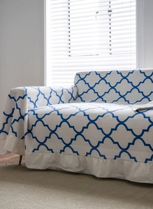 Detail of blue geometric ogee pattern on cream sofa cover with ruffled edge