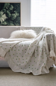 Detailed view of ruffle edges and lemon print on cream cotton sofa cover throw