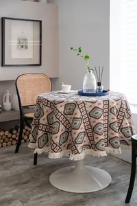 Detail of bohemian round tablecloth with geometric patterns and white fringe tassels