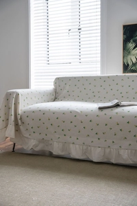 Detail of ruffle hem on lemon print sofa cover made of soft cotton linen fabric
