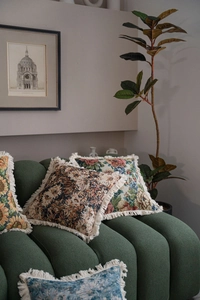 Macro detail of vintage floral jacquard pillow with thick cotton fabric and cream fringes
