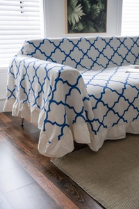 Detail of blue diamond print sofa cover with ruffled hem on minimalist beige fabric