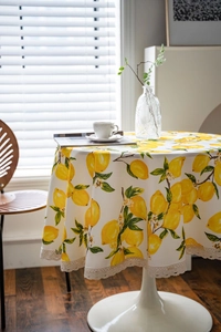 Close-up of fresh lemon print tablecloth with delicate beige crochet lace edging