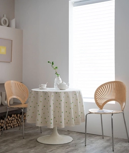 Detail of round tablecloth with lemon print and delicate white lace trim in natural light