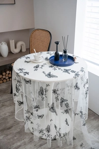 Close-up of black butterfly embroidery on white mesh lace tablecloth fabric