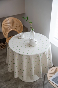 Detail of round lemon print tablecloth with lace trim in a cozy afternoon tea setting