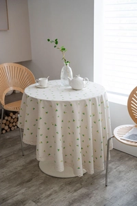 Detailed close-up of lemon floral round tablecloth with elegant white lace edge
