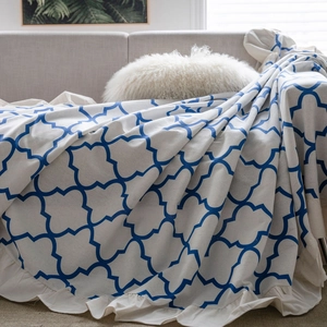 Off-white cotton linen sofa throw with blue diamond pattern and ruffle edge