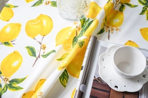Detailed texture of cotton linen tablecloth with fresh lemon print and green leaves