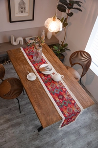 Close-up of bohemian red table runner featuring geometric jacquard patterns and white tassels