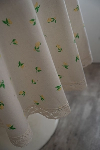 Detail of cotton linen tablecloth with lemon floral print and crochet lace edges