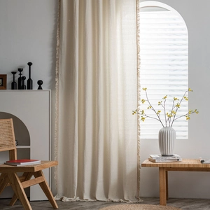 Elegant beige waffle textured window curtains with tassel fringe in a cozy home setting