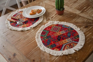 Detailed view of bohemian woven placemats with colorful geometric patterns and white fringe
