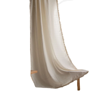 Minimalist waffle textured cream curtain with elegant tassel trim in a soft cotton fabric