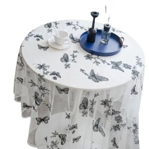 White lace tablecloth featuring black butterfly embroidery on a modern round dining table