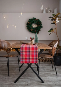 Detailed view of red plaid table runner with festive Christmas decor and warm lights