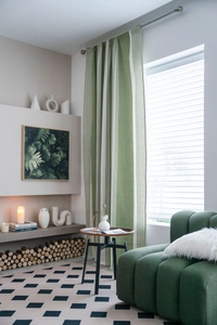 Detail view of green and white striped cotton linen curtain in a modern living room
