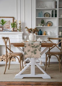 Detail of pine cone pattern and linen tassels on a rustic beige table runner