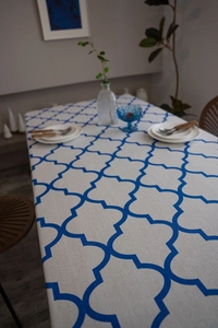 Detail of blue quatrefoil pattern on cotton linen tablecloth with neat stitching edge