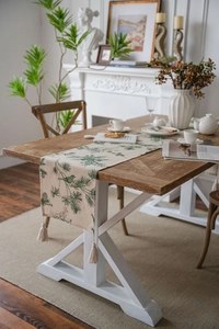 Linen table runner with green pine branch and bird print featuring off-white tassels