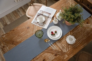 Close-up of blue and white striped table runner on a vintage wooden dining table decor