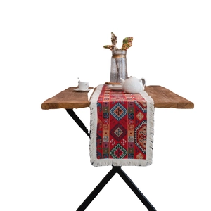 Ethnic red table runner with colorful geometric patterns and white fringe tassels