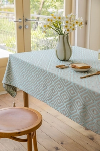Detailed view of jacquard geometric diamond tablecloth with blue decorative tassels
