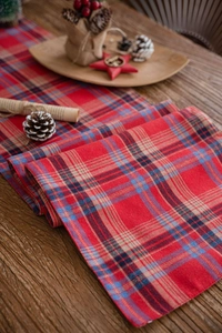 Detailed top view of red and blue plaid table runner with festive Christmas decorations