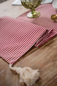 Close-up of red and white striped table runner with vintage cream tassel details