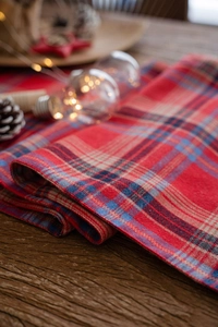Detailed texture of red and blue checkered table runner on a rustic wooden surface