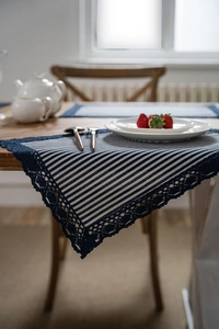 Close-up of blue white striped table runner with dark blue crochet lace trim