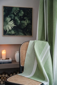 Close-up of green and white striped cotton linen curtain fabric on a chair
