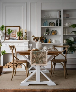 Dettaglio ravvicinato di un runner jacquard floreale con nappe beige su legno scuro