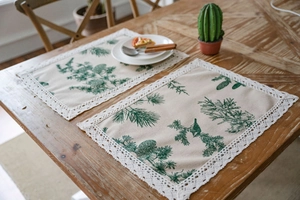 Close-up of pine needle pattern on cotton linen table runner with white lace edges