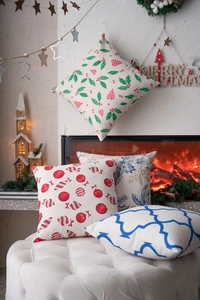 Cozy Christmas pillow covers with assorted festive holiday prints set in a warm fireplace scene