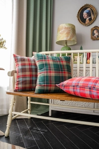 Detailed texture of green and red plaid festive cushion covers on a vintage wood bench