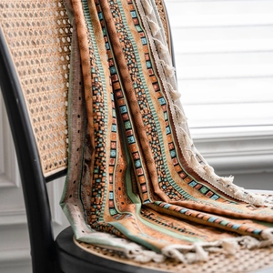 Bohemian yellow striped cotton linen semi-blackout curtain with tassels on a chair