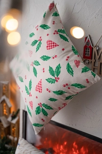 Detail of Christmas pillow cover with red heart and holly print on cotton linen fabric