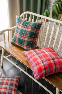Texture detail of festive green plaid decorative cushion cover on a rustic bench