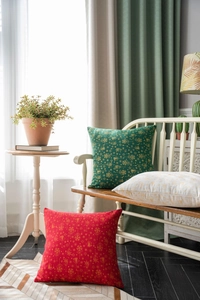 Detail of Christmas pillow covers featuring gold printed holiday patterns on green fabric