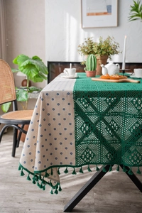 Detail of blue daisy floral tablecloth with green hollow crochet lace and tassel fringe