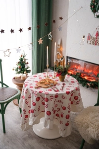 Close-up of festive round tablecloth with red candy prints and ruffled edges