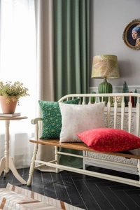 Close-up of festive green and red Christmas pillow covers with gold snowflake patterns