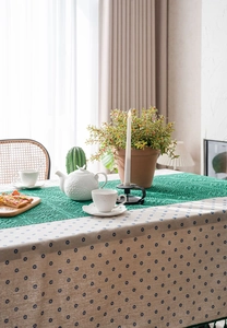 Detailed close-up of blue floral cotton linen tablecloth with green lace runner
